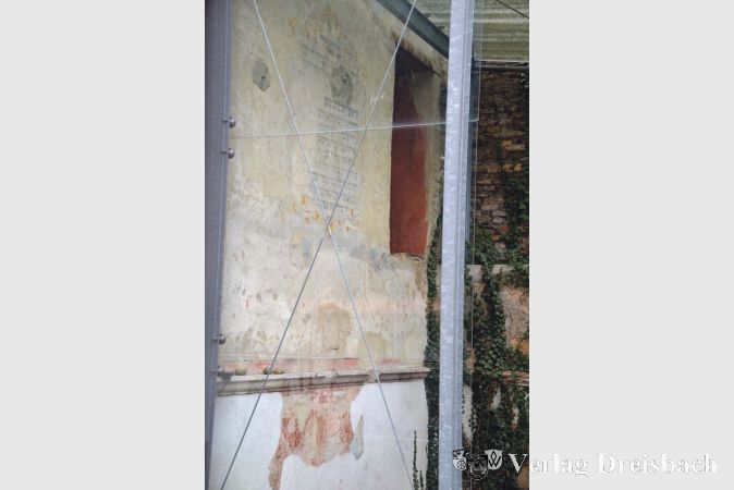 Eine einzige Wand der 1718 errichteten Synagoge ist nach der Zerst&ouml;rung 1938 erhalten geblieben. Sie ist mit einem Blick durch das Mauerfenster des Anwesens in der Synagogengasse zu sehen.

&nbsp;