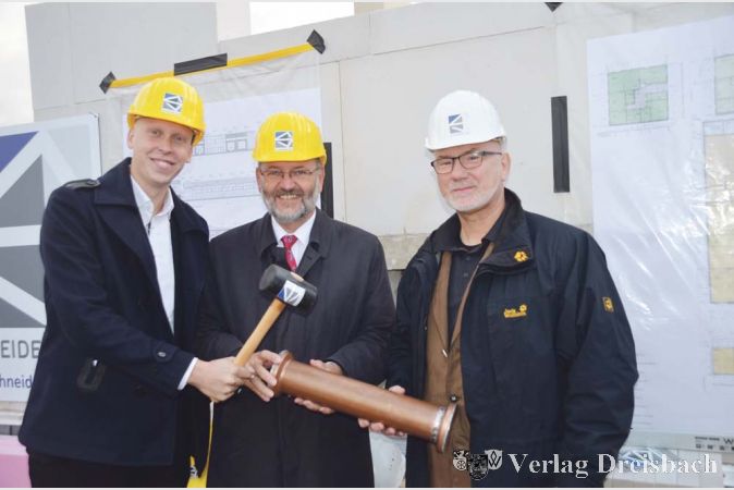 Michel Schneider, Juniorchef der Firma &bdquo;Schneider Bau&ldquo;, B&uuml;rgermeister Michael Antenbrink und Planer J&uuml;rgen Keller (von links) vollzogen die Grundsteinlegung am neuen Bauhof.