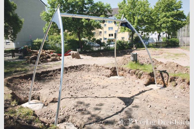 Die neue Doppelschaukel steht auf vier soliden Beinen, die Kuhle wird noch mit Spielplatzsand aufgef&uuml;llt.