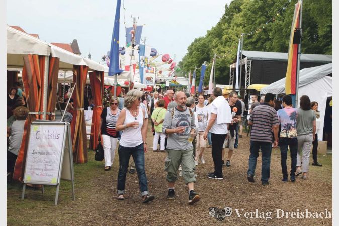 Eine &quot;Flaniermeile&quot; gibt es angesichts des begrenzten Raumes, den die St&auml;nde beim Altrheinfest einnehmen, streng genommen zwar nicht. Aber flanieren lie&szlig; es sich auf der Wiese, die dank Rindenmulchs einiges an Regenwasser verkraften konnte, durchaus.