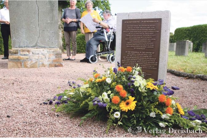 Die Gedenktafel weist darauf hin, dass im Jahr 2007 an dieser Stelle, dem Gr&auml;berfeld der im Zweiten Weltkrieg beim Luftangriff auf Bischofsheim gestorbenen B&uuml;rger, einst ein Kranz zum Gedenken an die deutschen und englischen Kriegstoten niedergelegt wurde.