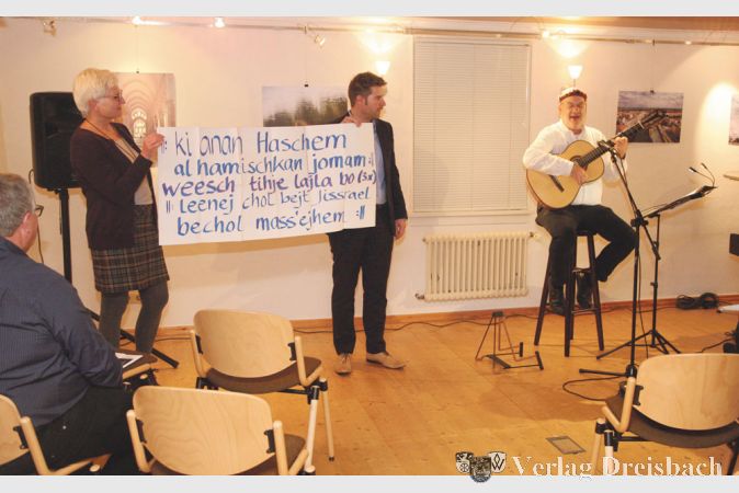 Elisabeth Mudersbach und Ingo Kalweit hielten ein Plakat mit lautmalerischem Text hoch, um den Zuh&ouml;rern das Mitwirken bei einem hebr&auml;ischen Wechselgesang zu erm&ouml;glichen.