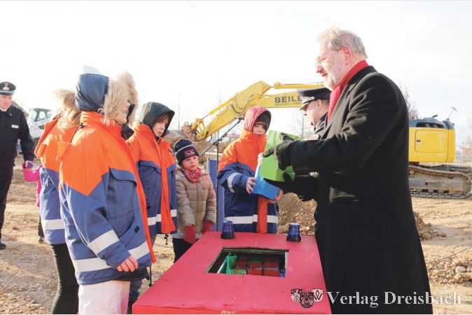 B&uuml;rgermeister Michael Antenbrink beteiligte sich gerne daran, mit Peer Neugebauer zur Erinnerung an den Spatenstich kleine Geschenke an die Mitglieder der Weilbacher Jugendfeuerwehr zu verteilen.