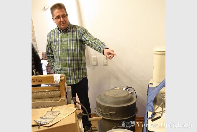 Marcel Anthes erklärt die Funktion einer historischen Waschmaschine.