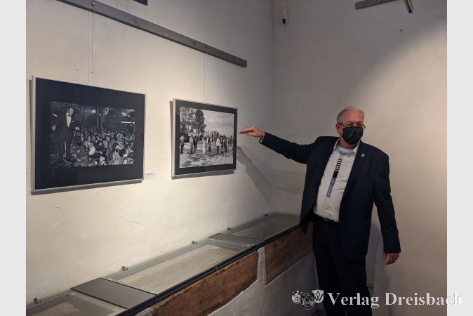 Erster Stadtrat Karl Heinz Spengler erläuterte anhand der ausgestellten Bilder das Aussehen von Hattersheim vor 50 Jahren. Hier verweist er auf die große Freifläche, auf der zwei Jahre später die Stadthalle stehen sollte.