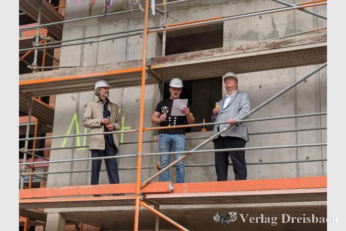 Hawobau-Geschäftsführer Holger Kazzer (links) und Bürgermeister Klaus Schindling (rechts) lauschen dem Richtspruch, den in Vertretung eines Zimmermanns Patrick Vogel von der f.m.a. bau GmbH verlas.