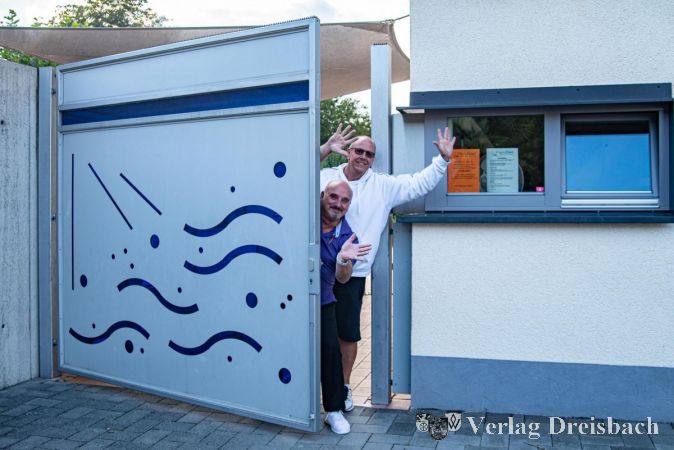 Schwimmmeister Ralf Stössel (hinten) und Kassierer Michael Göldner sagen "Tschüss" und schließen das Parkbad-Tor bis zur nächsten Saison 2022.