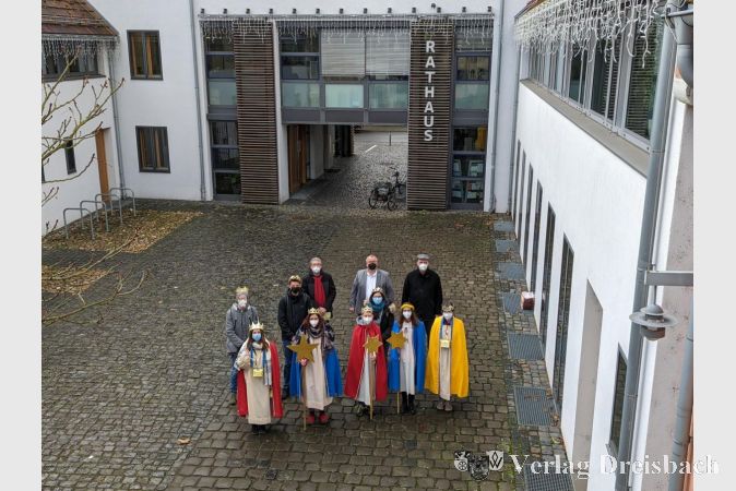 Die Sternsinger im Innenhof des Nassauer Hofes, zusammen mit Pfarrer Andreas Klee (hinten rechts), Gemeindereferent Joachim Kahle (hinten links) und Bürgermeister Klaus Schindling (hinten Mitte).