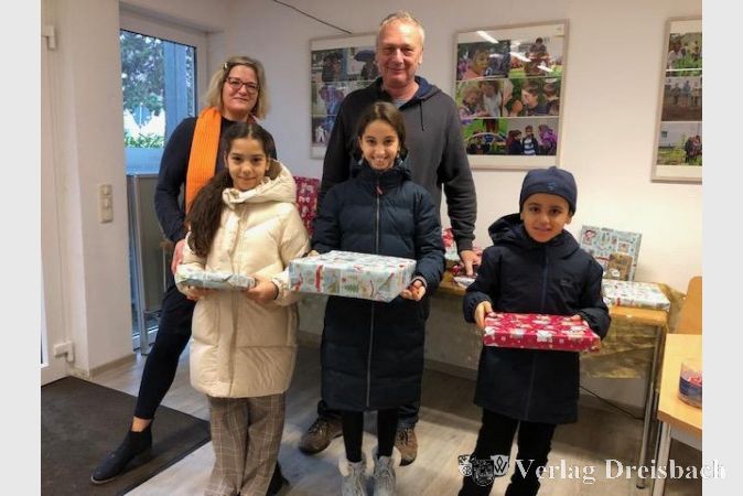 Eva Hamann von der Familienoffensive und Eberhard Roth vom Stadteilbüro mit drei beschenkten Kindern.