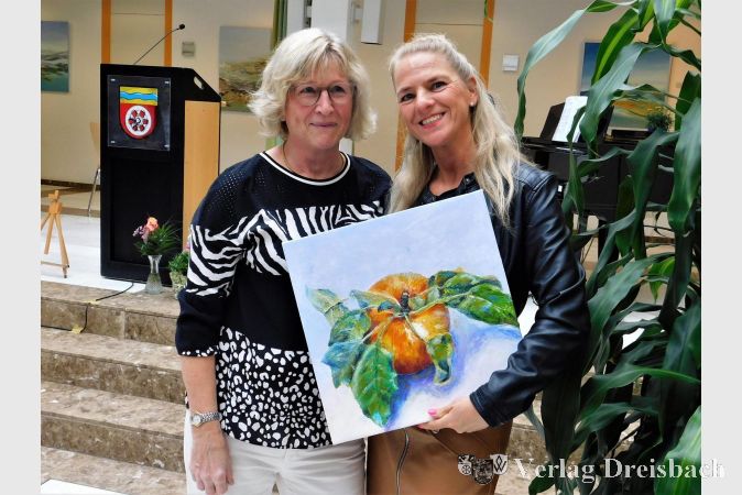 Foto mit der Künstlerin. Angelika Fink hält freudig ihr ersteigertes Gemälde im Arm.