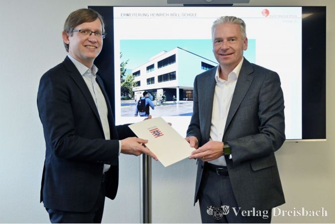 Landrat Michael Cyriax (rechts) und Staatssekretär Jens Deutschendorf bei der Bescheidübergabe im Landratsamt.