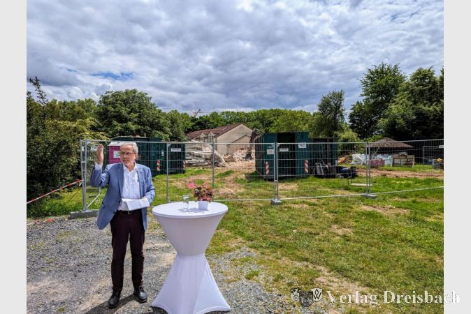 EVIM-Vorstand Jörg Wiegand beim Festakt mit Spatenstich vor der Baustelle. Im Hintergrund wird gerade der Abriss des alten Gebäudes in der Dürerstraße 19 abgeschlossen.