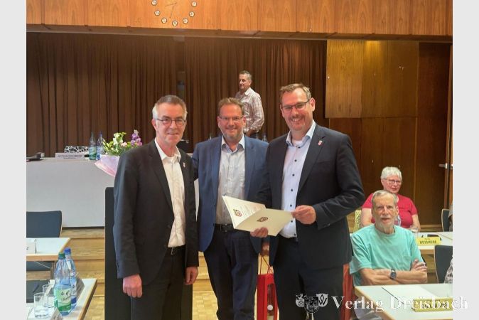 V.l.n.r.: Der Erste Beigeordnete Franz Jirasek, der Vorsitzende der Gemeindevertretung Alexander Feist und Bürgermeister Christian Seitz mit seiner neuen Ernennungsurkunde.