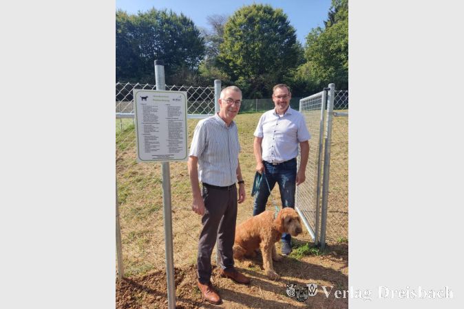 Der Erste Beigeordnete Franz Jirasek sowie Bürgermeister Christian Seitz mit Hund Bailey am Eingang zur neuen Hundewiese.