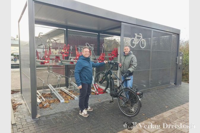 Der Erste Beigeordnete Martin Mohr (links) und Michael Knittel vom Bauamt vor der neuen Fahrradsammelschließanlage.