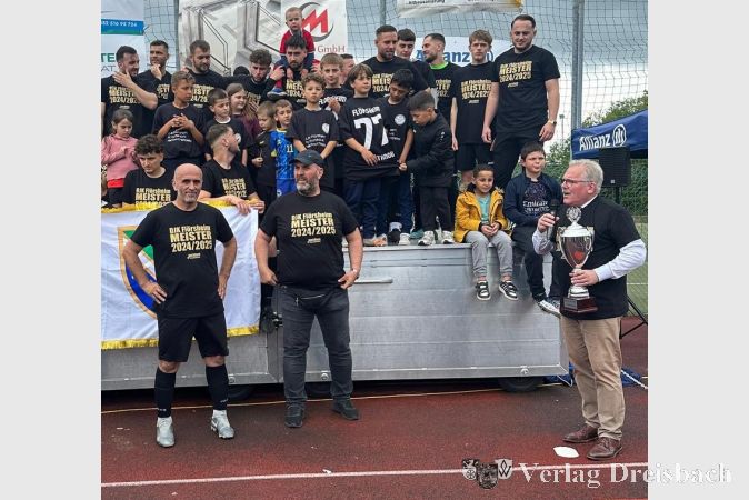 Bürgermeister Bernd Blisch überreichte nach dem letzten Saisonspiel den Meisterpokal an die Teamverantwortlichen der DJK II.