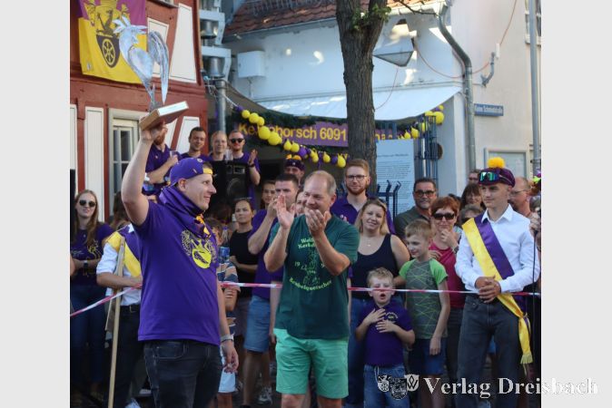 Pascal Schäfer (l.) reckt den Siegerpokal des Gickelschlags in die Höhe, den er von seinem Vorgänger, Ortsvorsteher Thomas Schmidt (Mitte), überreicht bekam. Ein traditioneller Höhepunkt bei jeder Weilbacher Kerb.
