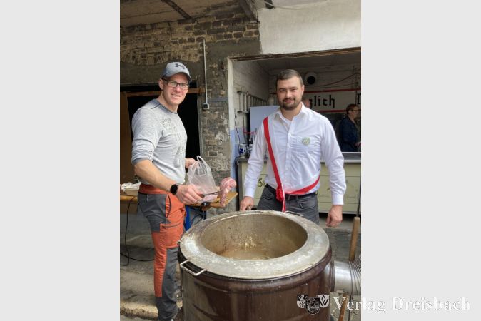 Die Vereinsmitglieder, Tristan Dalfuß (rechts) und Maikel Wilker, kümmern sich um die Versorgung der Gäste mit Rippchen und Kraut.