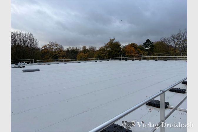 Das Dach der großen Halle. Die Dachhaut ist fertig und das Geländer ist angebracht. Blitz-schutz und PV-Anlage folgen noch.
